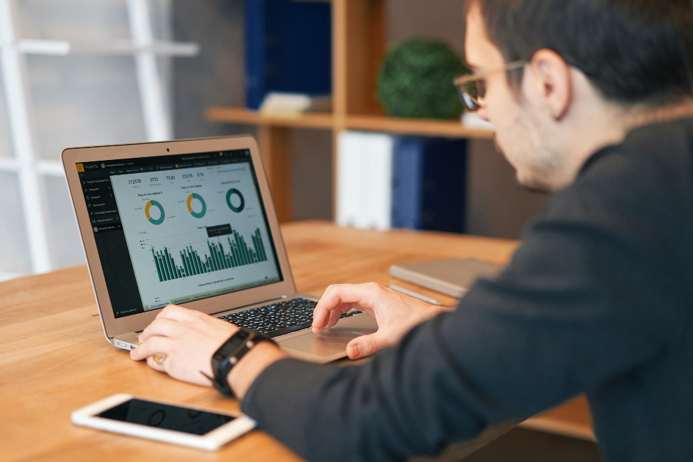 Closeup of man working on laptop with finances or ceo, graph, business analytics and strategy
